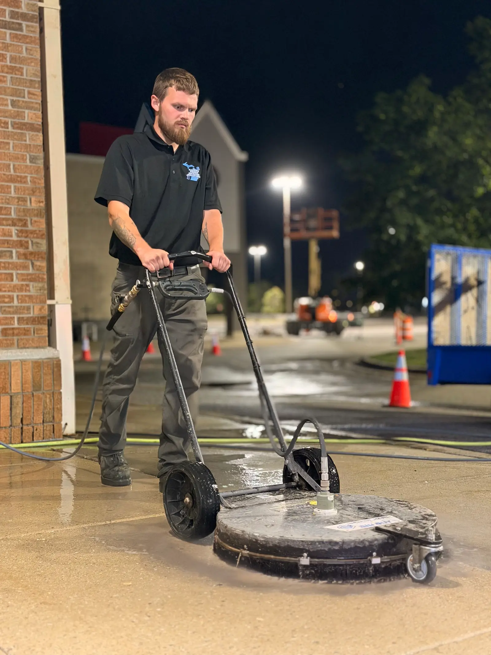 MPWS technician running a rotary surface cleaner across a commercial concrete walkway